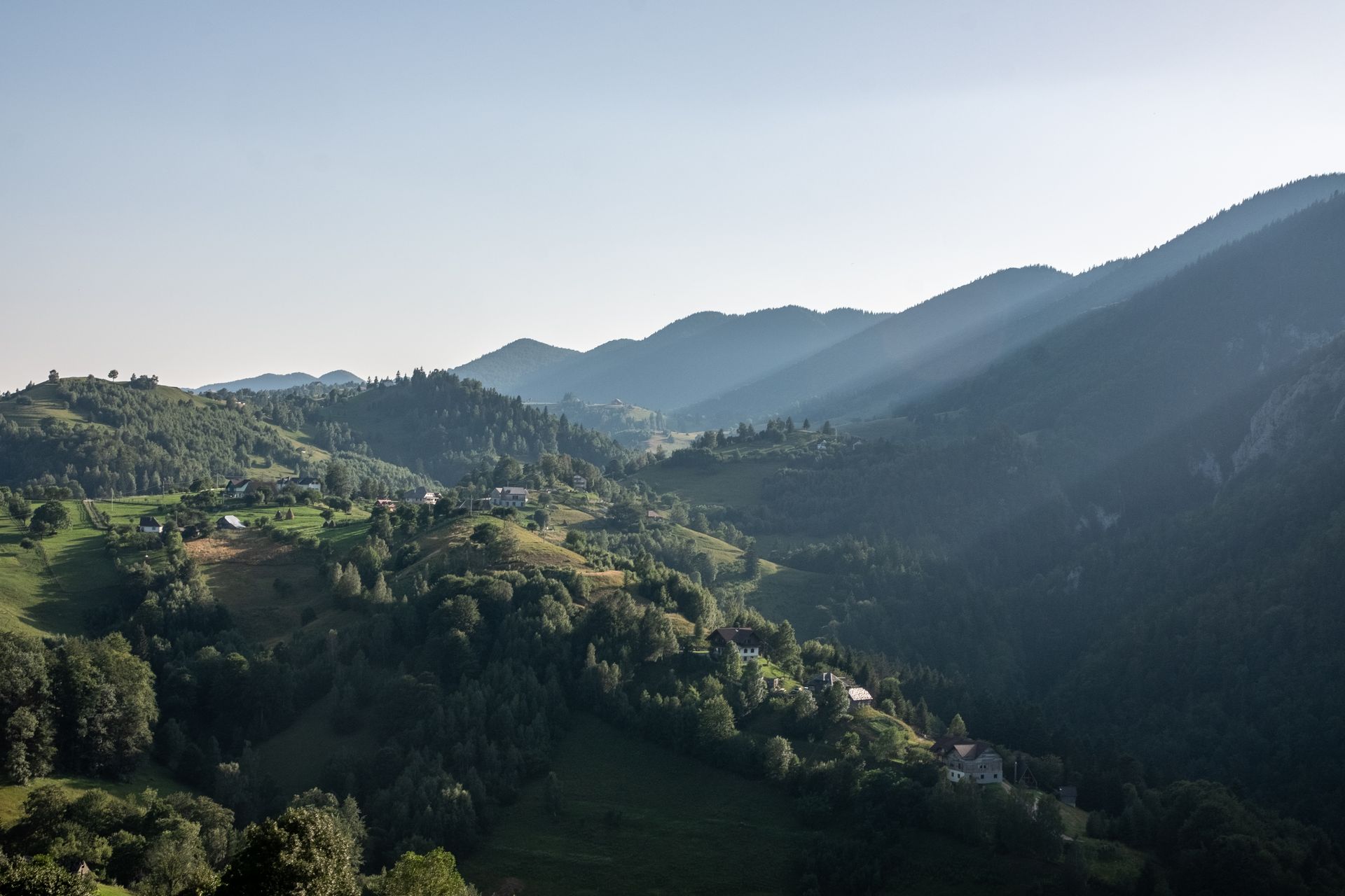The Măgura village and Piatra Craiului foothills inside the Zărnești bioregion, sunlit.